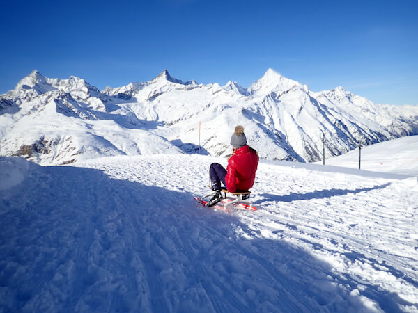 sledging in switzerland Girl in the Swiss mountains on Sledge - Taffpixture/shutterstock